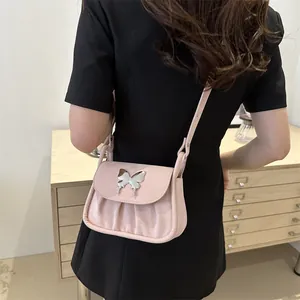 Detail der rosa Plissee-Schultertasche mit silberner Schmetterlingsschnalle und Gurt