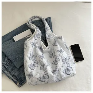 Gros plan d'un sac cabas doux à imprimé papillon bleu avec texture en maille duveteuse