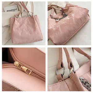Detalles del bolso rosa con textura de mármol, cadena plateada y cierre de cremallera
