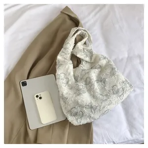 Détail du sac cabas en toile crème avec imprimé papillon et bords texturés en peluche