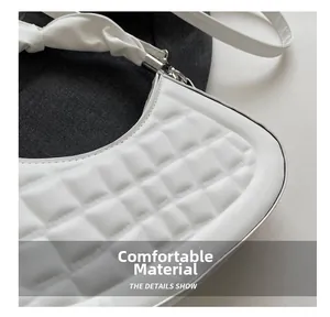 Close-up of white quilted faux leather texture with unique knot shoulder strap detail