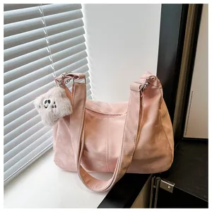 Close-up of pink oversized tote bag featuring matte texture and a cute plush charm accessory