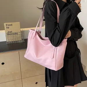 Détail d'un grand sac fourre-tout rose avec texture en nylon brillant et bandoulières