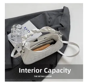 Internal capacity of the white pleated handbag showing space for phone and wallet