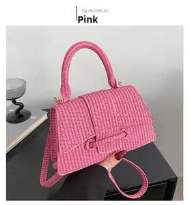 Détail du sac à main rose à texture tressée avec poignée chic et boucle métallique