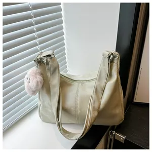Detail view of the soft synthetic leather texture and cute pink plush ball charm