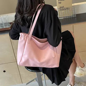Détail du sac cabas en cuir rose clair avec bord plissé élégant et fines bandoulières