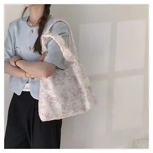 Détail du cabas en toile crème avec motif papillon en dentelle rose texturé et élégant