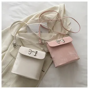 Vista detallada de bolsos bandolera cuadrados con cierre de lazo plateado en tela suave