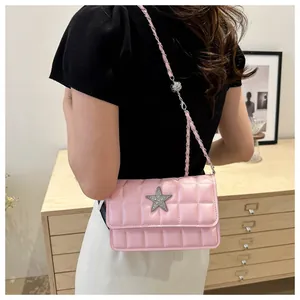 Detail of pink quilted PU leather crossbody bag with a sparkling rhinestone star emblem