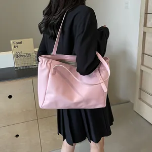 Grand sac cabas rose en cuir synthétique porté par un mannequin dans un cadre épuré