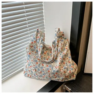 Détail d'un sac cabas souple en toile à imprimé fleuri sous une lumière naturelle douce