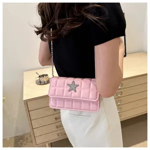 Pink quilted crossbody bag with a silver star ornament and chain strap detail