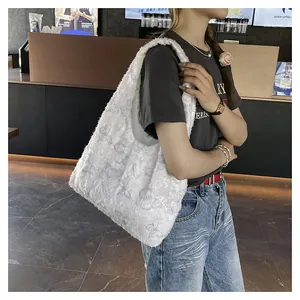 Détail du sac bandoulière en fausse fourrure blanche avec broderie papillon grise