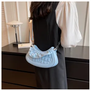 Detail of light blue quilted shoulder bag with wave pleated edge and metal hook