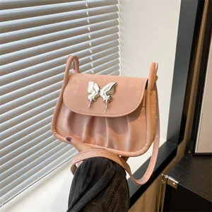 Makro-Detail der rosa gefalteten Umhängetasche mit einem silbernen Metallschmetterling