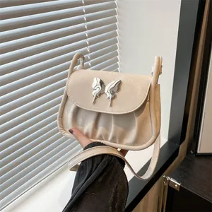 Detailaufnahme der cremefarbenen Falten-Schultertasche mit Metall-Schmetterlingsschnalle