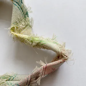 Macro shot of plaid fabric handle with fringe details and woven cotton texture