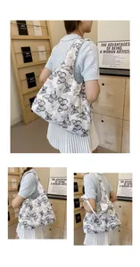 Vue détaillée du sac cabas en toile blanche avec broderie papillon en dentelle noire