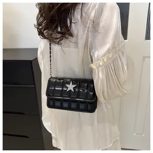 Close-up of quilted black crossbody bag with silver star crystal buckle and chain strap