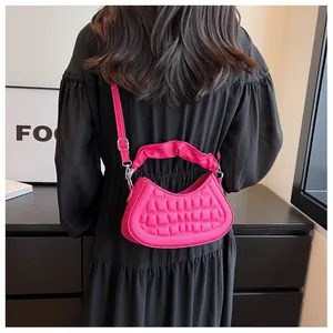 Detail of fuchsia pleated handle and quilted crescent handbag with shoulder strap