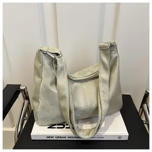 Detail of light green tote bag with matte texture placed on a white design book