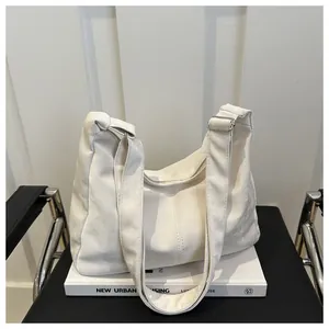 Detail of white soft fabric tote bag with adjustable silver buckle on a modern chair
