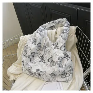Détail du sac en toile pelucheuse blanche avec imprimé papillon noir vintage dans un panier
