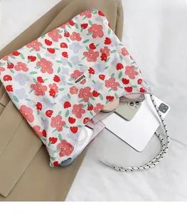 Detail of floral tote bag showing large capacity for tablet, phone, and braided handles