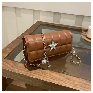 Macro view of brown quilted chocolate pattern crossbody bag with star rhinestone detail