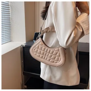 Detailed view of beige pleated handle and quilted rhombic pattern on a hobo bag