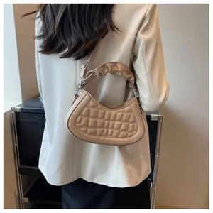 Detailed view of beige pleated handle and quilted pattern on women shoulder bag