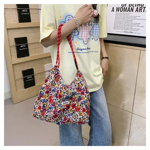 Floral canvas tote bag with red rope straps and Sunshine label shown on model