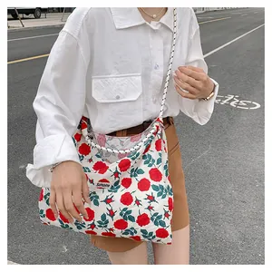 Detail of floral canvas tote bag featuring red rose patterns and Sunshine label