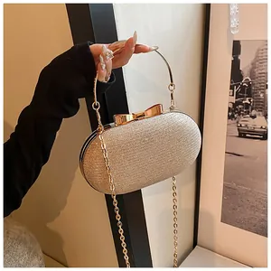 Detail of champagne gold glitter evening bag with round metal handle and bow clasp