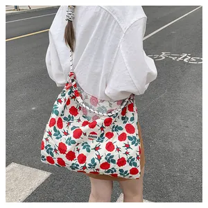 Floral tote bag with red roses and Sunshine label on a woven black and white rope strap