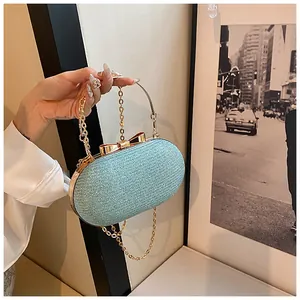 Detail of light blue glitter clutch bag with golden handle and bow decoration