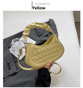 Detail of yellow pleated handbag with waffled texture on a stylish blazer background
