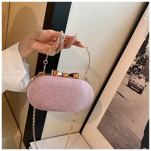 Detail of pink glitter clutch bag with golden bow clasp and circular metal handle