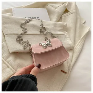 Detail of pink marble textured crossbody bag with silver butterfly buckle and chain