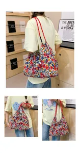 Detailed close-up of floral tote bag with woven rope handles and Sunshine label patch