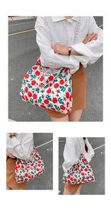 Detail of floral tote bag showing sunshine label, red rose pattern, and sturdy canvas handles
