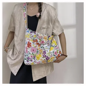 Detail of floral canvas tote bag featuring vibrant flower patterns and wide shoulder strap