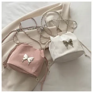 Detail of pink and white bucket bags with silver butterfly buckle and chain strap