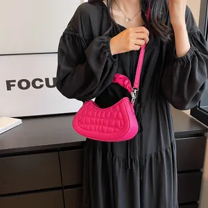 Hot pink quilted half-moon crossbody bag with elegant pleated texture and handle strap