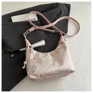 Détail du sac bandoulière en satin rose avec motif jacquard d'architecture chinoise