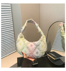 Detail of frayed edge denim canvas bag with colorful star pattern and macaron stitching