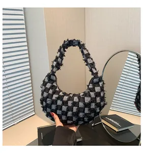 Detail of checkered canvas hobo bag with frayed edges and moon shaped minimalist design