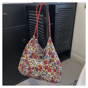 Detailed macro of floral canvas tote bag with red rope handle and Sunshine patch