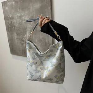 Close-up of golden butterfly embroidery on high-quality silk fabric shoulder bag